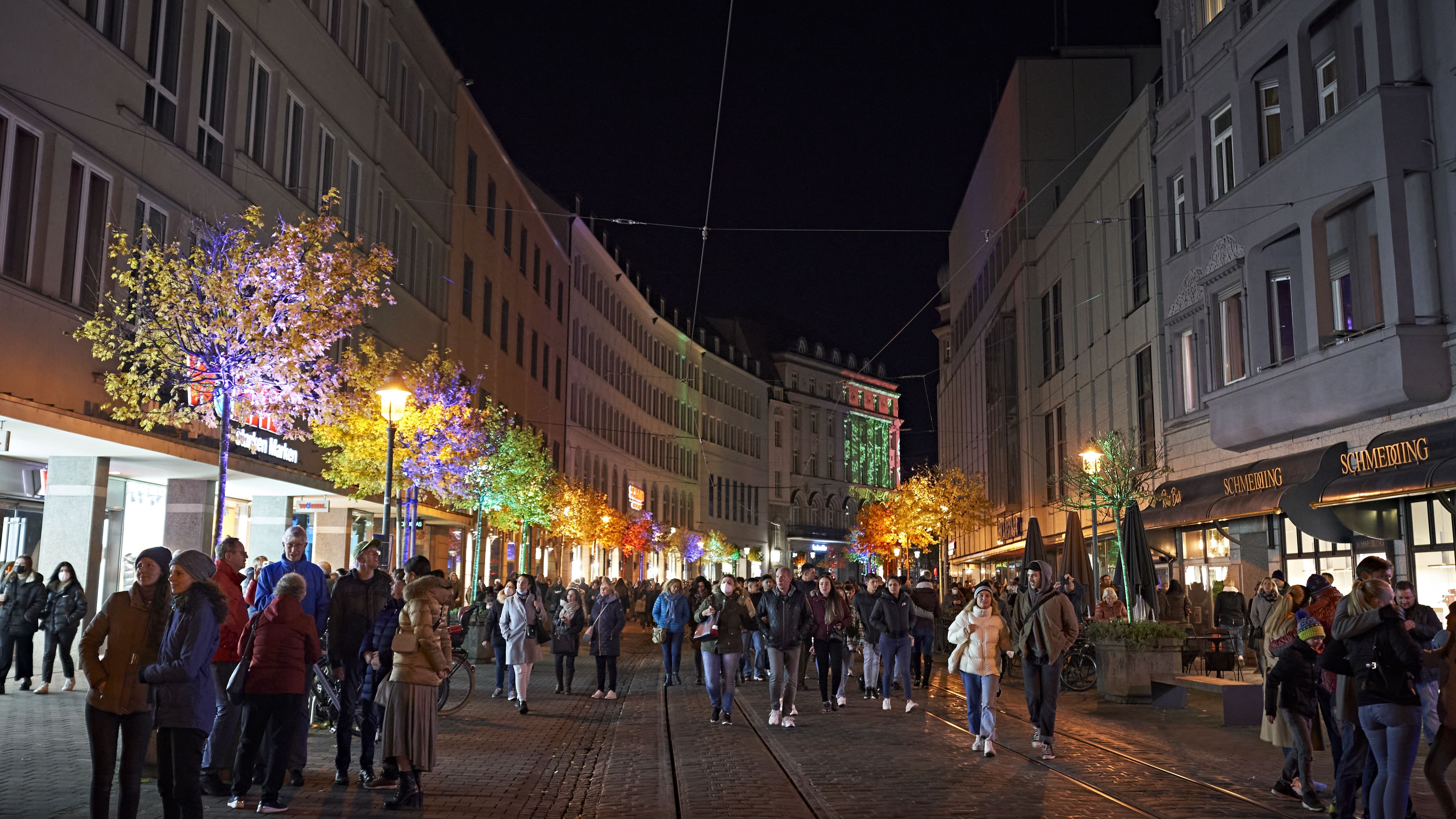 Das Foto zeigt die Bürgermeister-Fischer Straße bei Nacht. Die Geschäfte sind beleuchtet und  es sind viele Menschen auf der Straße zu sehen.