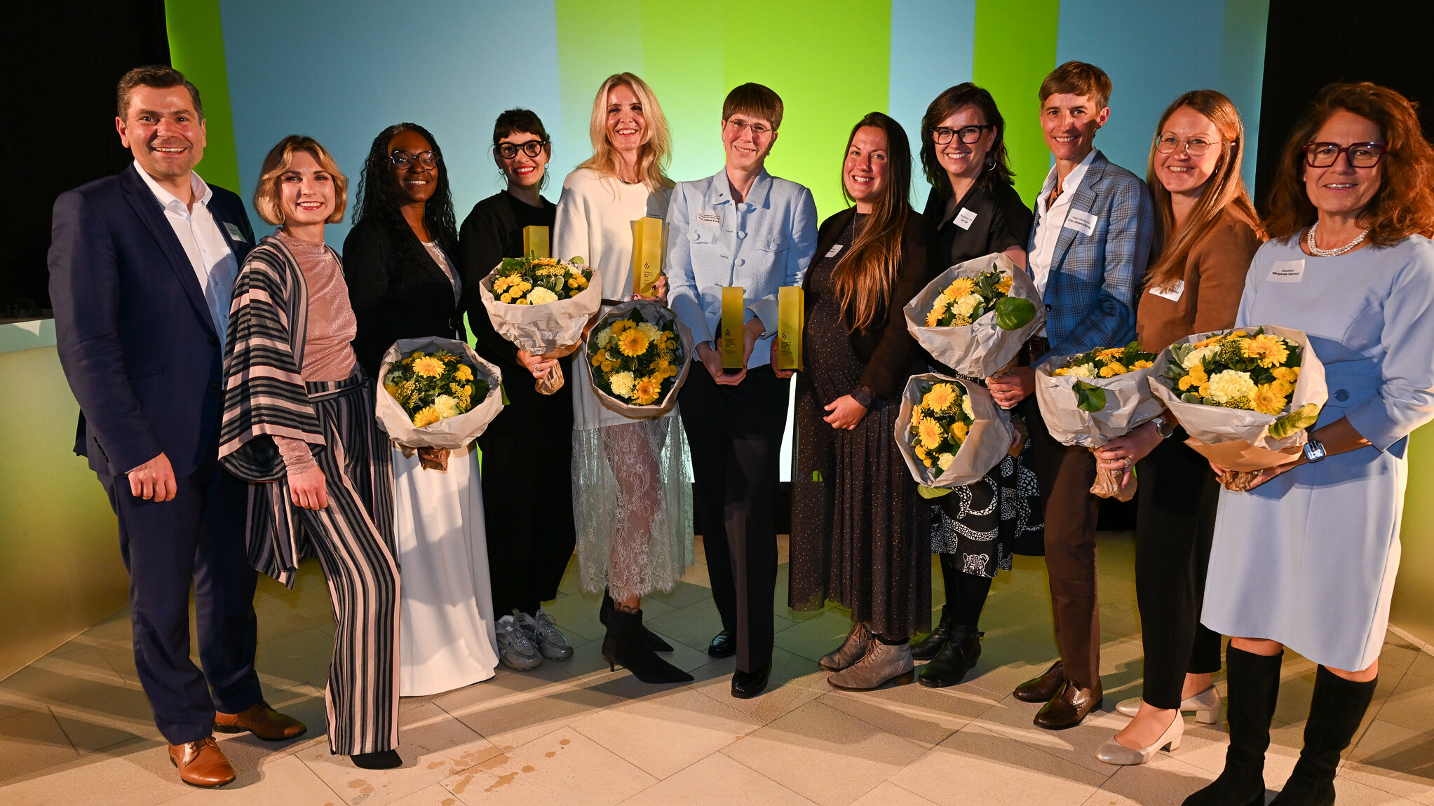OB Dr. Florian Freund und zehn Frauen. Einige halten Blumensträuße in der Hand