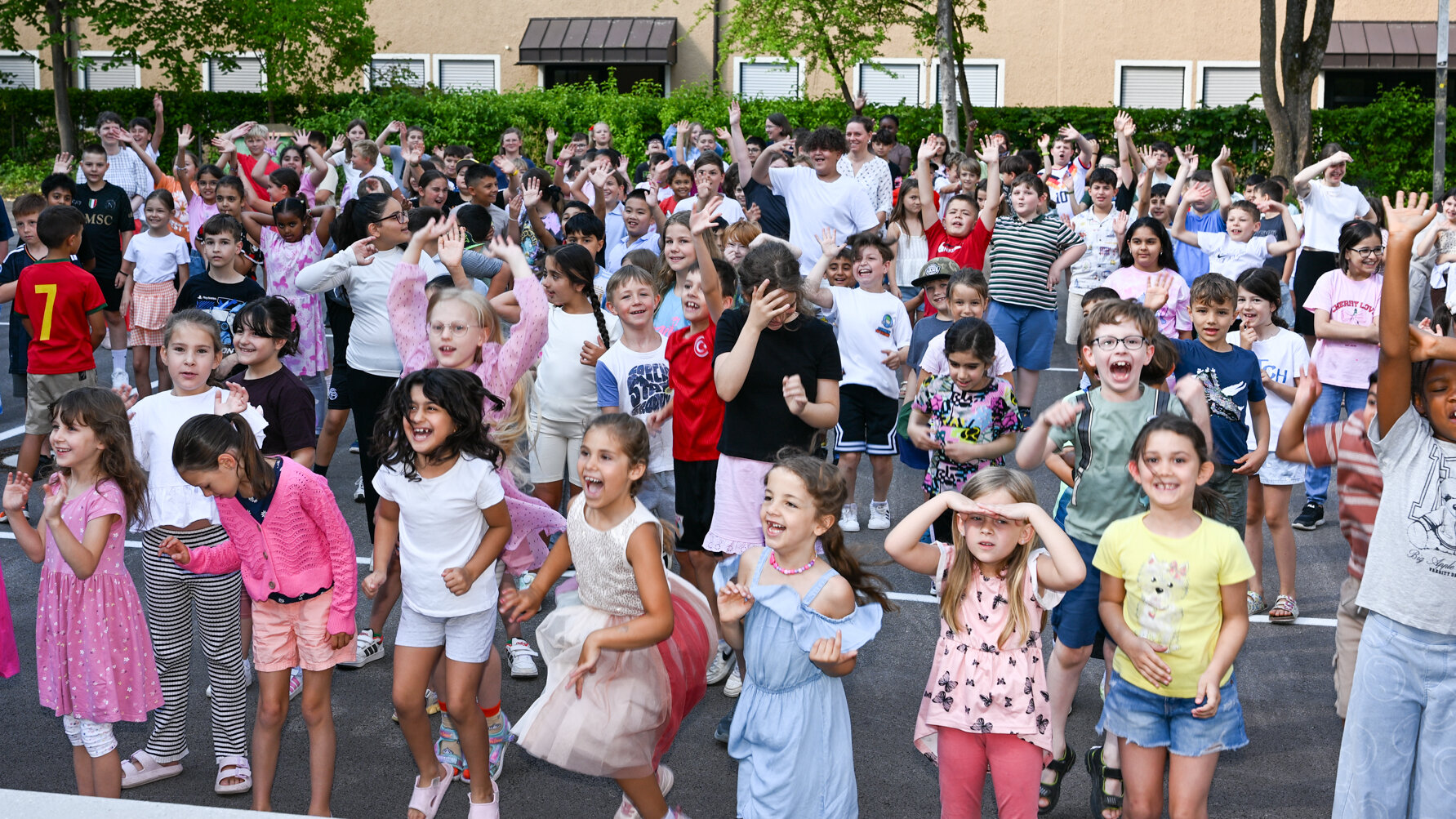 Schulkinder stehen im Pausenhof und jubeln