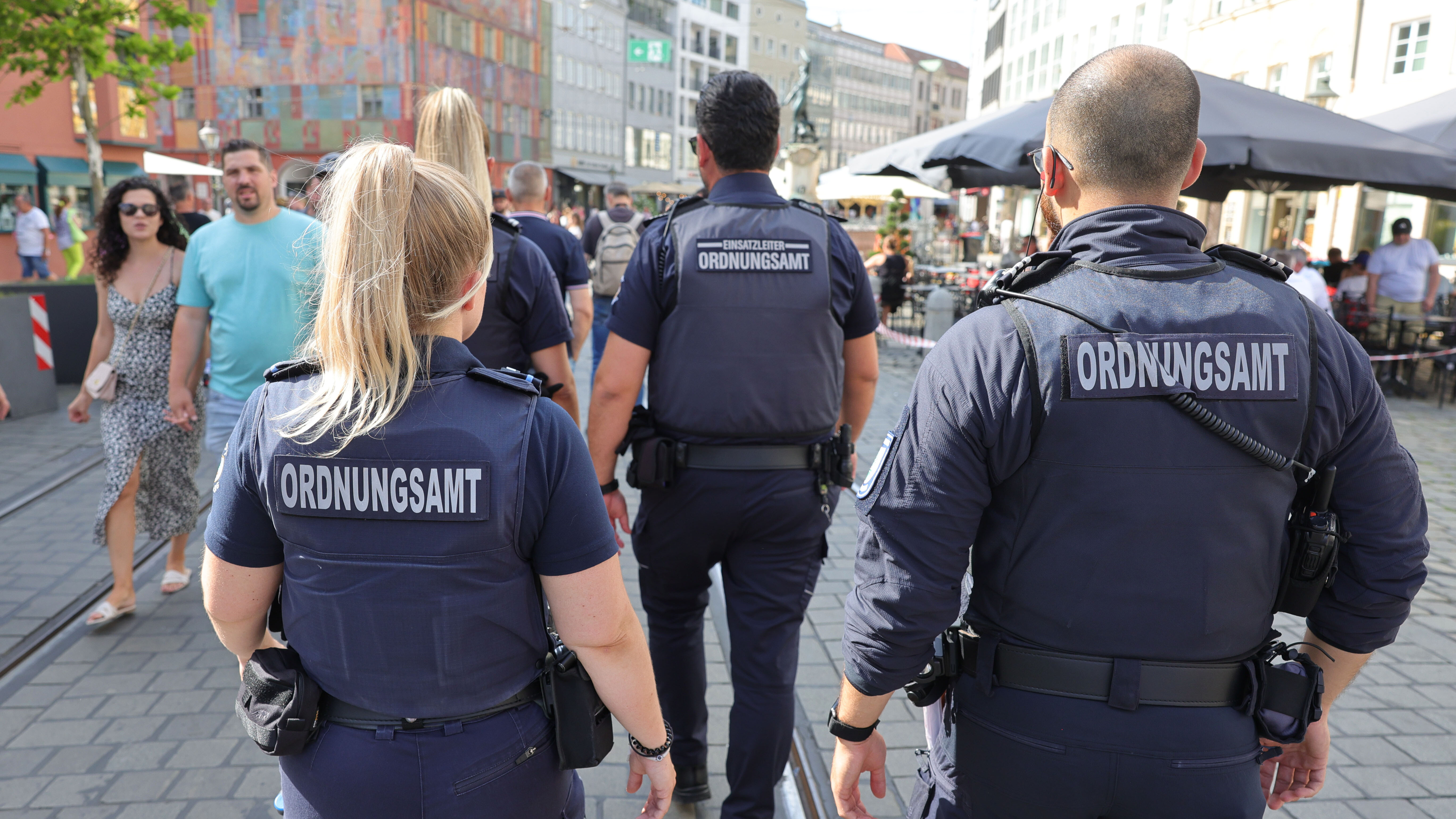 Mitarbeitende des Ordnungsdienstes laufen durch die Maximilianstraße