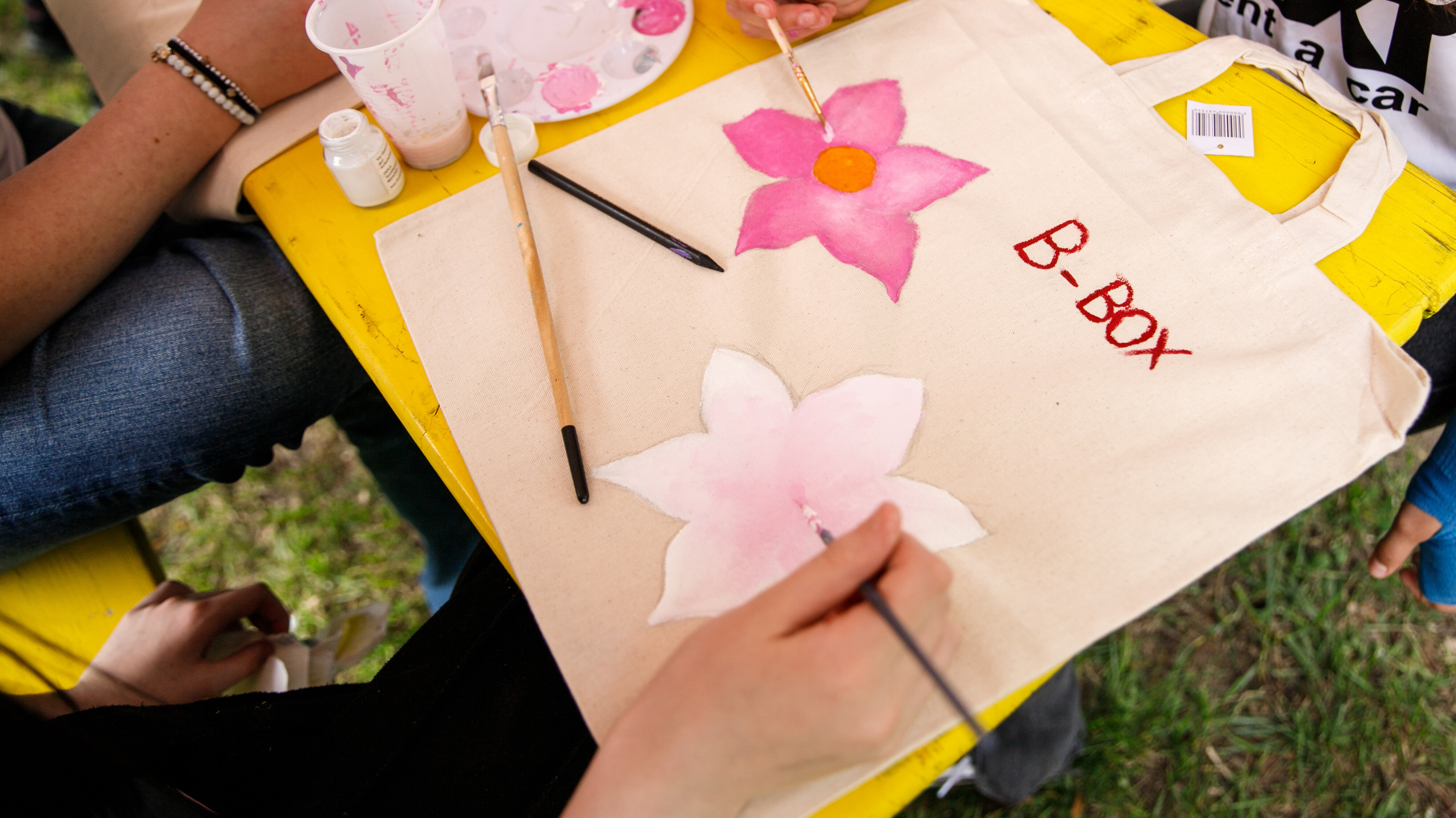 Bemalte Stofftaschen mit rosa Blüten. Schriftzug b-box.
