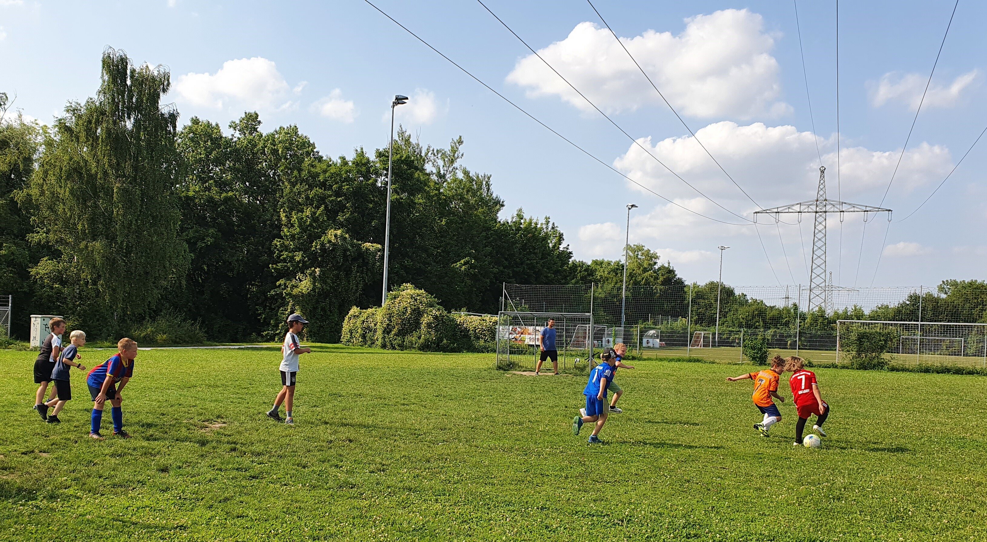 Kinder spielen Fußball auf einem Bolzplatz