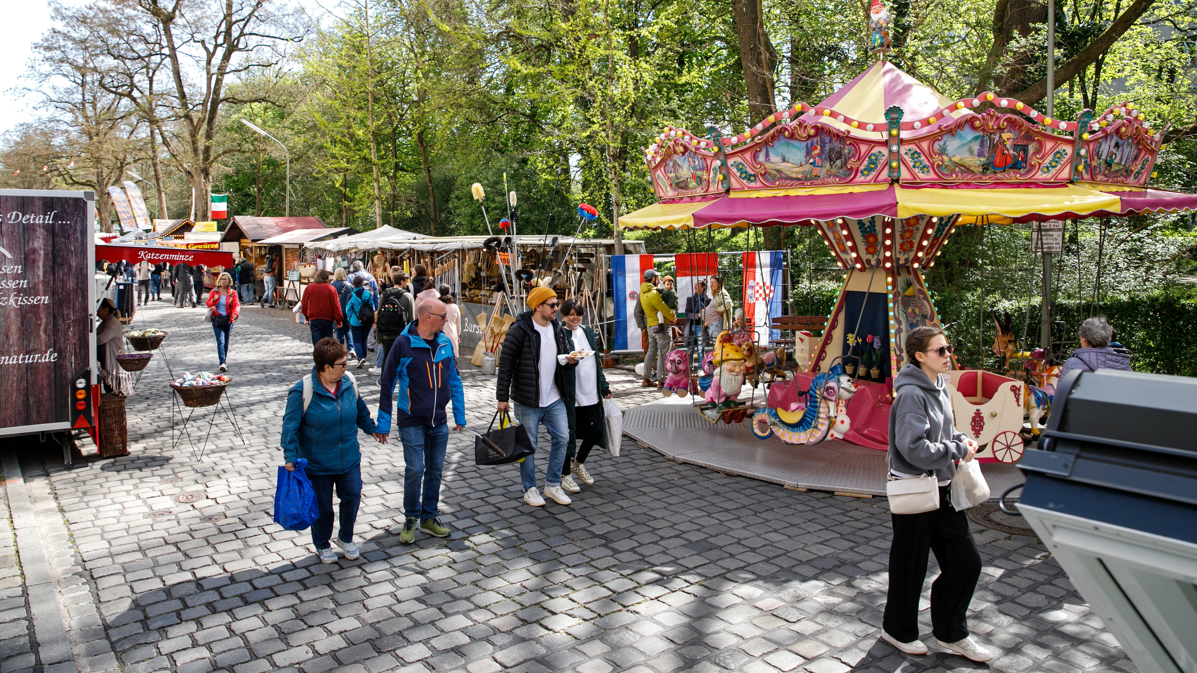 Menschen flanieren durch die Augsburger Dult zwischen Vogel- und Jakobertor