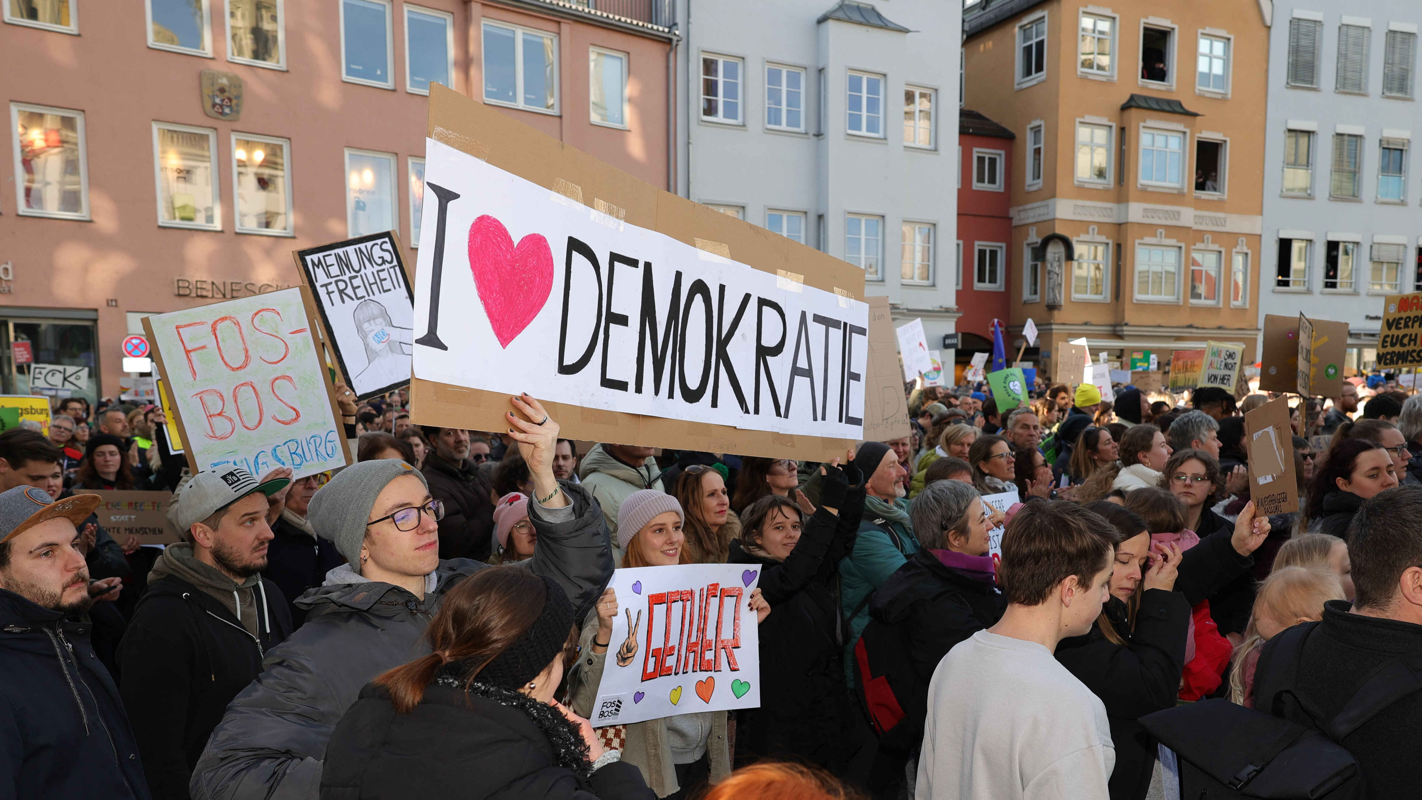 Bei einer Demonstration auf dem Rathausplatz wird ein Schild hochgehalten, auf dem I love Demokratie steht