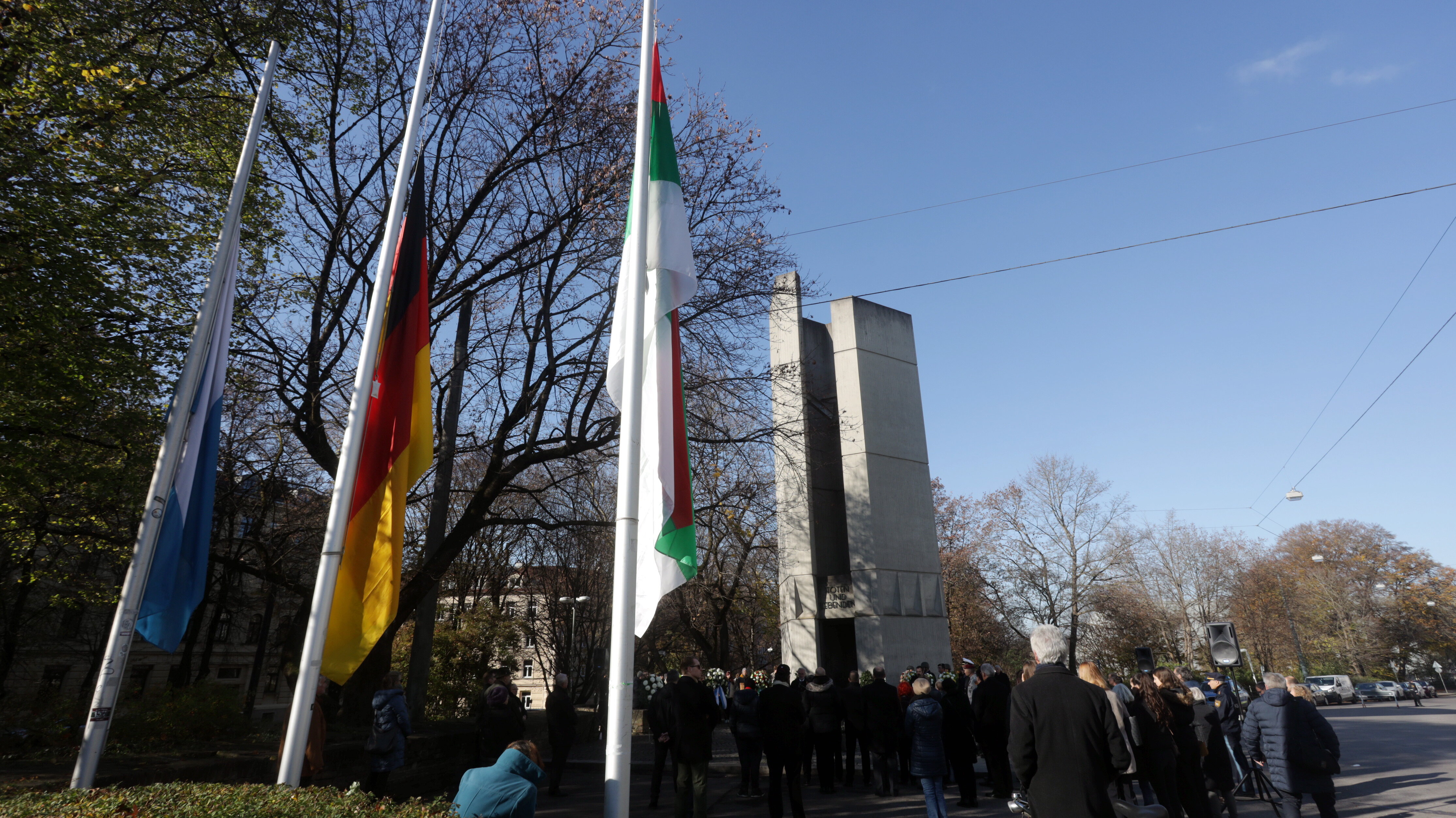 Mahnmal An der Blauen Kappe, davor zwei Fahnen: die deutsche und die in Augsburger Stadtfarben