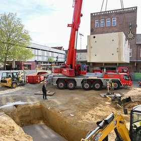 Einsetzen der Brunnenkammer auf dem Bauernmarkt. 