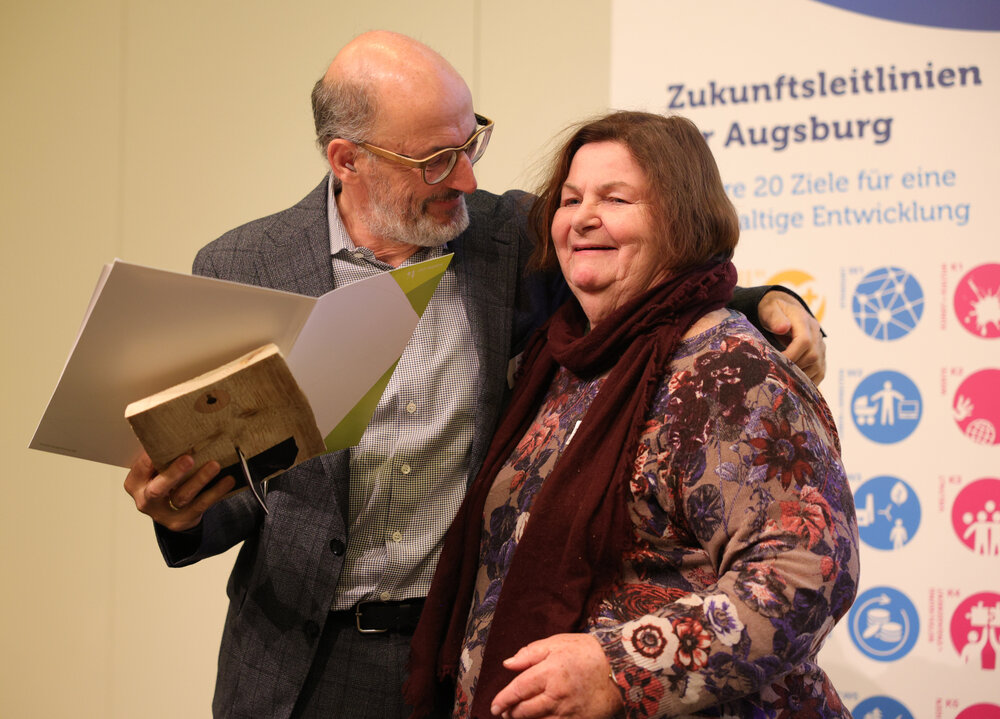 ein älterer Mann nimmt eine Frau in den Arm