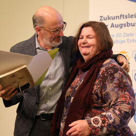 ein älterer Mann nimmt eine Frau in den Arm