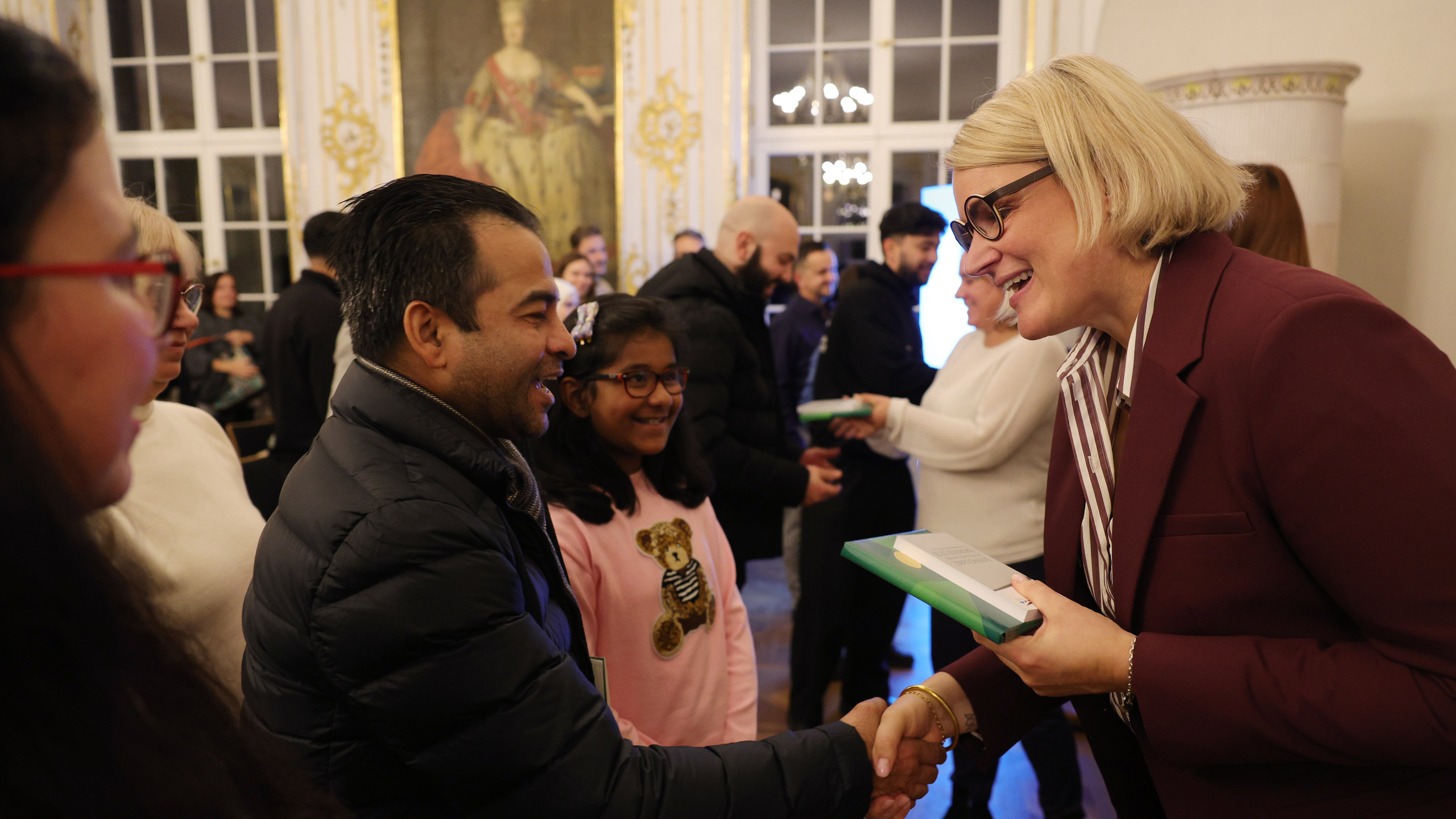 OB Eva Weber schüttelt einem Mann mit dunkler Hautfarbe die Hand