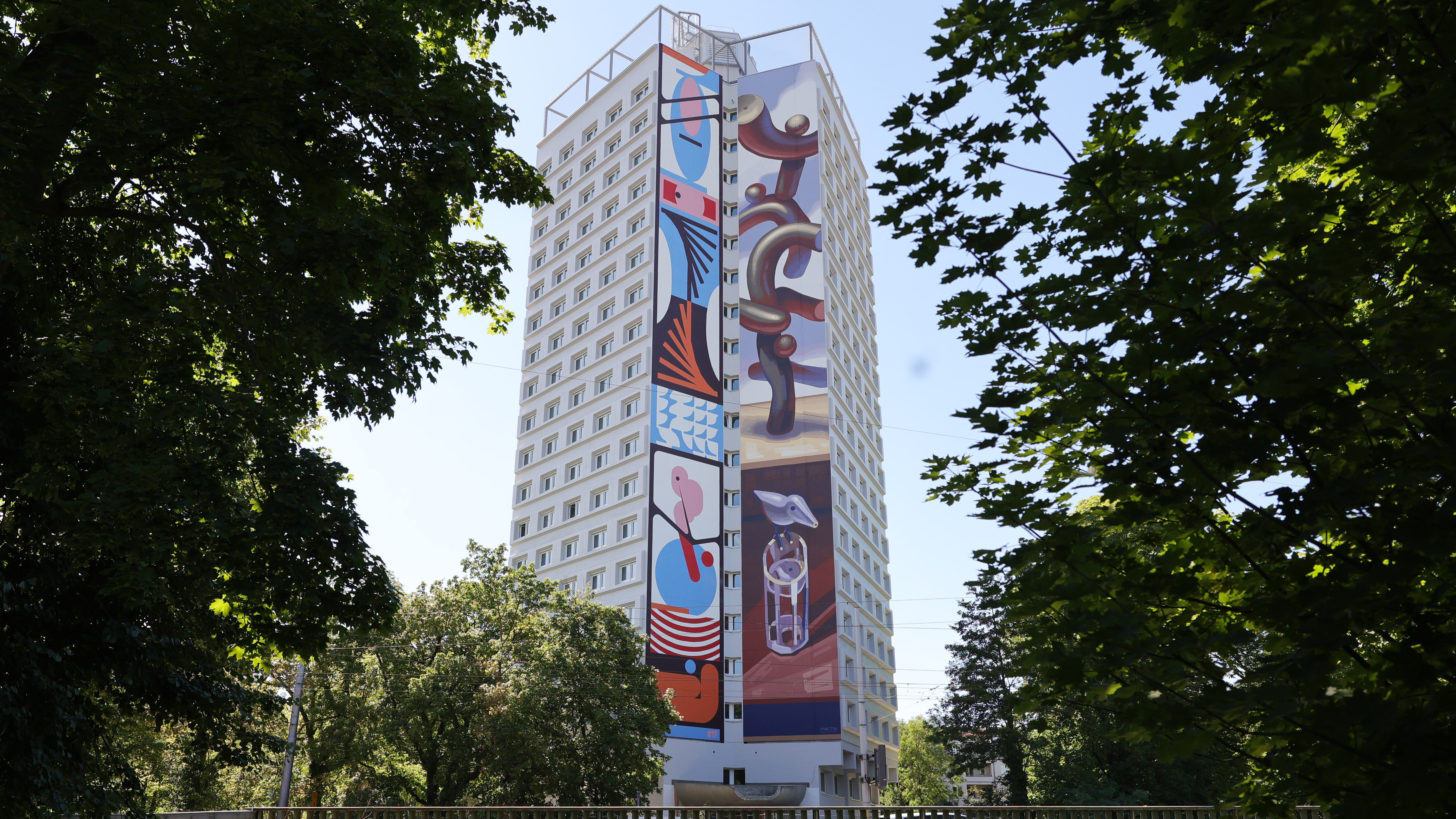 Das Foto zeigt ein Hochhaus. Die Fassade des Hohchhaus ist bunt bemalt.