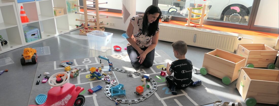Pädagogin mit Kind in der Bauecke der städtischen Mini-Kita Wertachstraße Pädagogin mit Kind in der Bauecke der städtischen Mini-Kita Wertachstraße