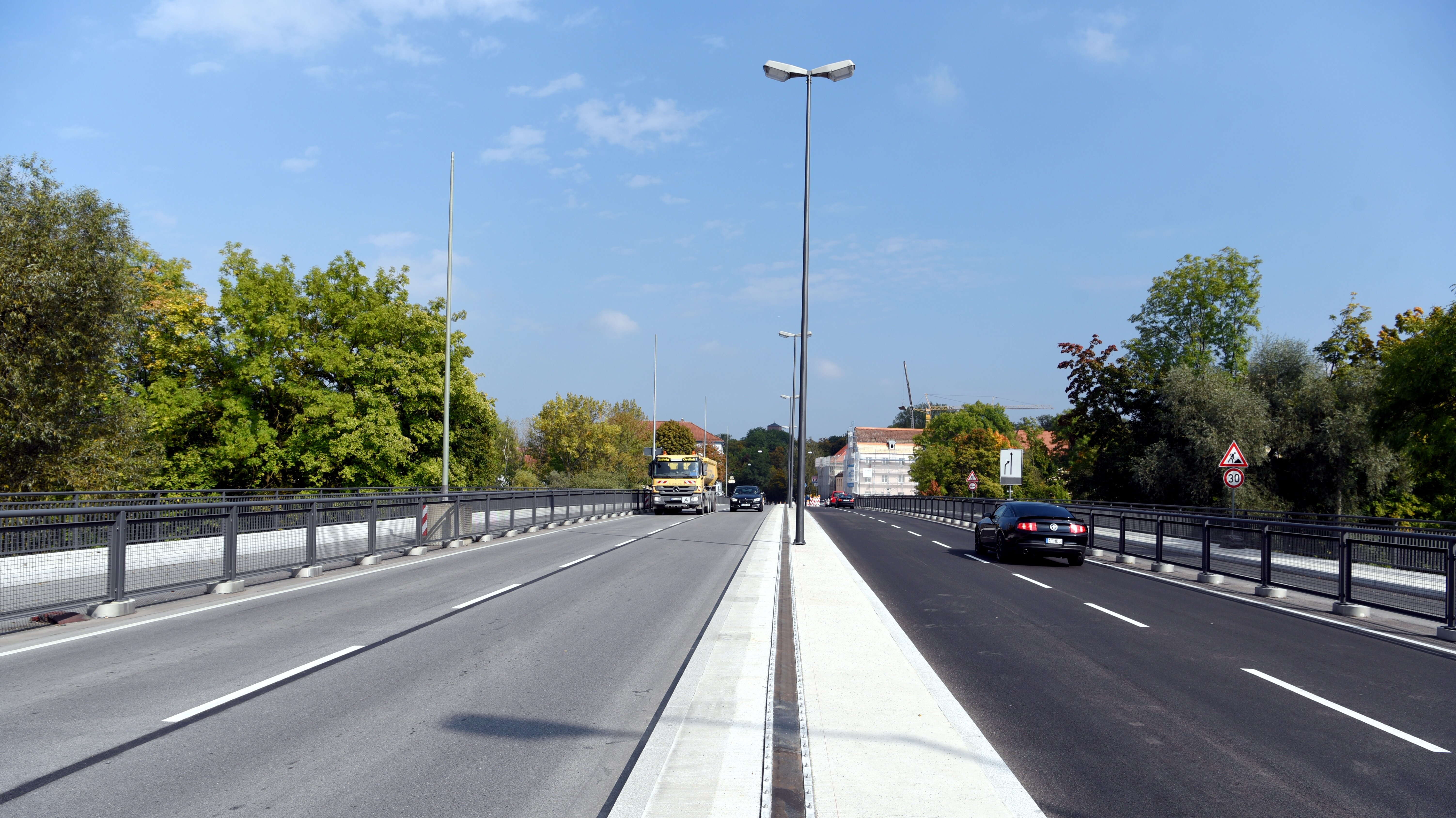 eine Brücke mit 4 Fahrspuren sowie einem breiten Radweg rechts und links, darauf diverse Fahrzeuge