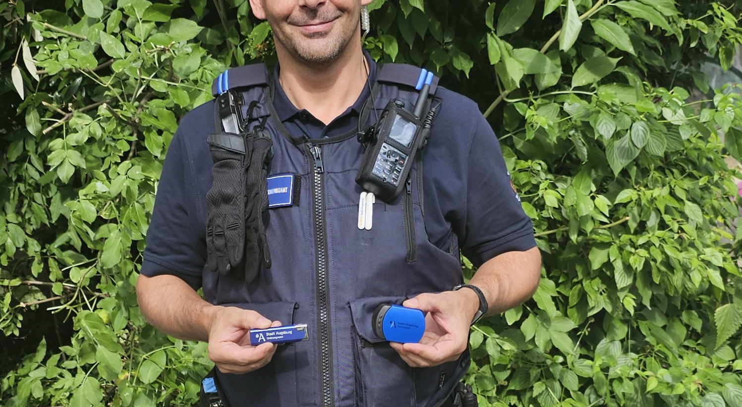 lächelnder Mensch in Uniform zeigt Taschenaschenbecher