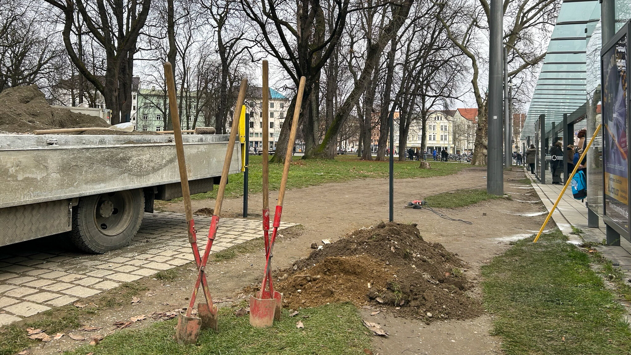 Ein Trampelpfad durch eine Grünanlage. Werkzeug wie Schaufeln und Spaten ist vorbereitet