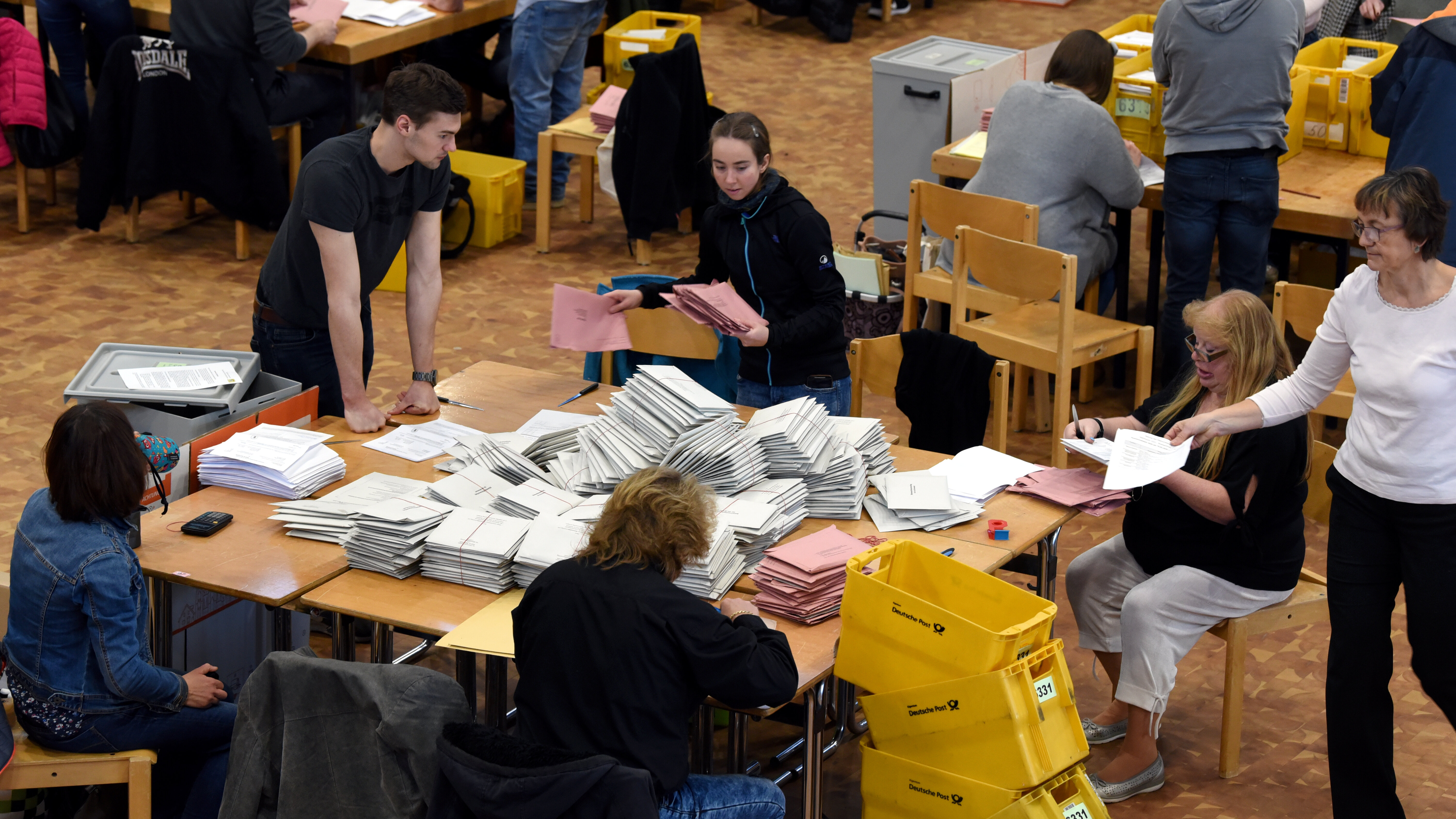 Sechs Leute um einen Tisch, auf dem viele Papiere liegen