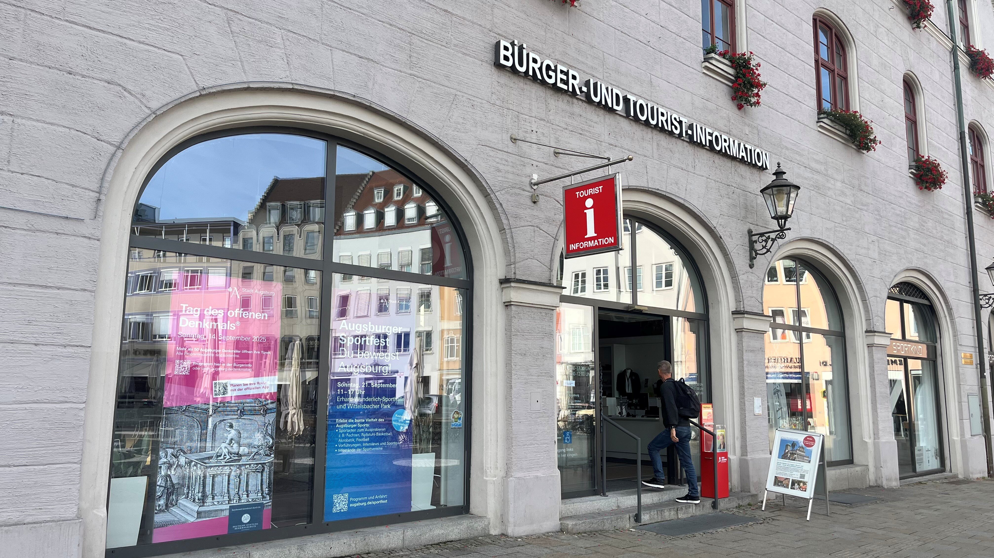 Ein Mann betritt ein Geschäft. Über dem Eingang steht "Bürger- und Tourist-Information"