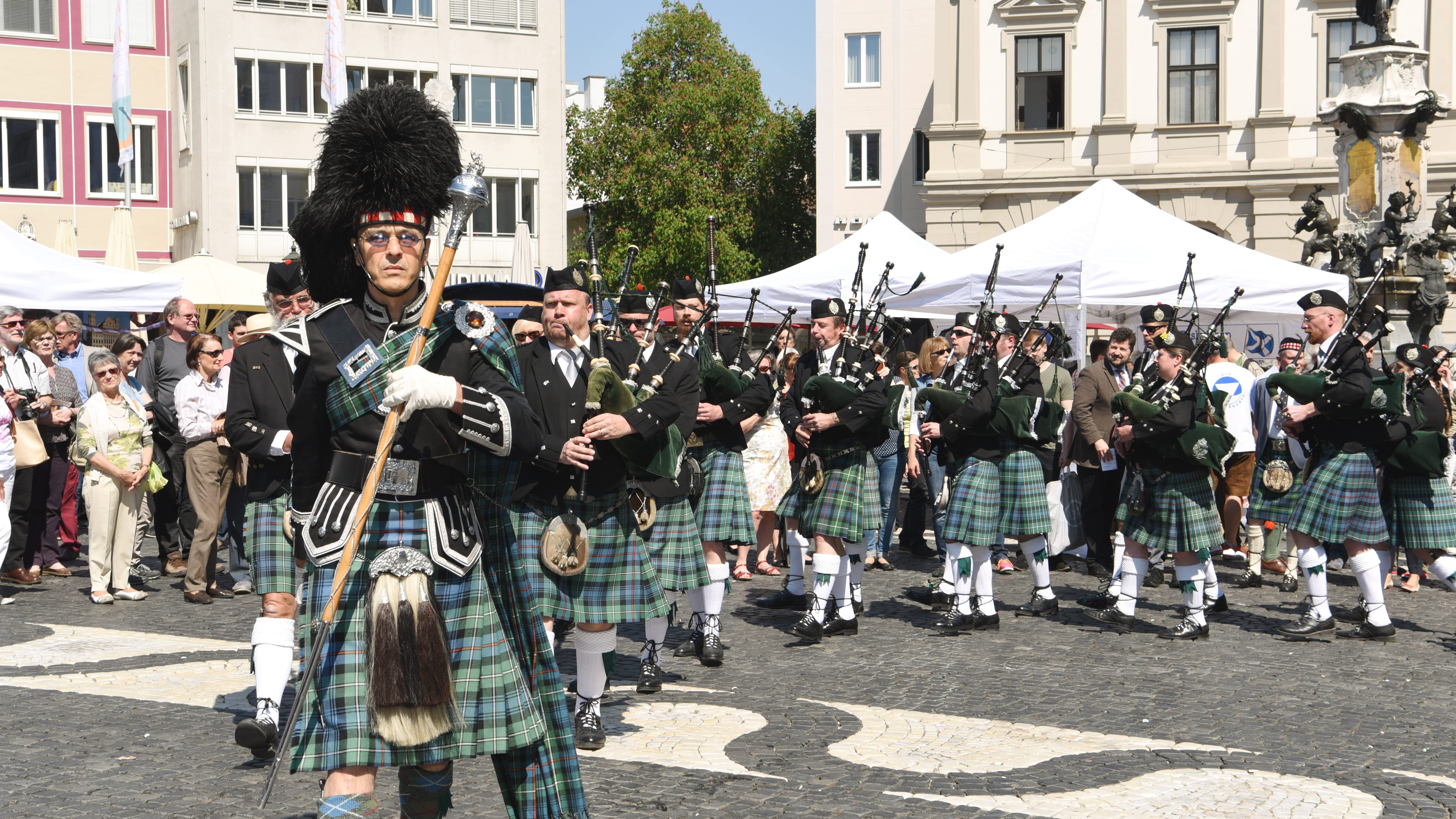 Neben dem Augustusbrunnen läuft eine Reihe von Dudelsackbläsern im Kilt