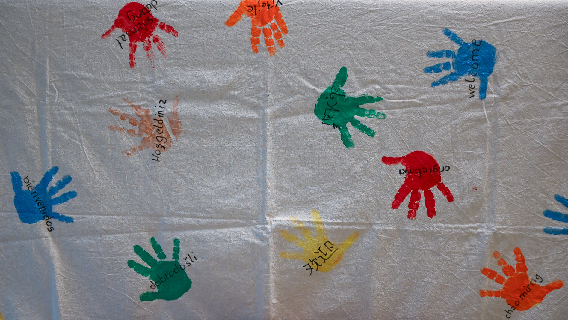 Bunte Abdrücke von Kinderhänden auf einem weißen Tuch