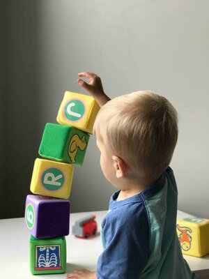 Kleinkind baut Turm aus Würfeln auf