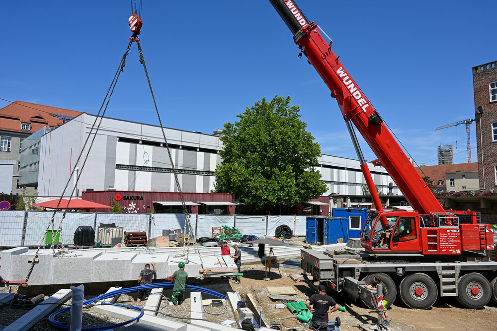 Mit schwerem Kran wird die Brunnenplatte angeliefert