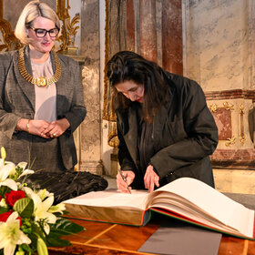 Emine Sevgi Özdamar trägt sich ins Goldene Buch der Stadt Augsburg ein.