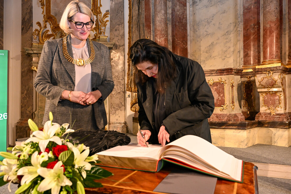 Emine Sevgi Özdamar trägt sich ins Goldene Buch der Stadt Augsburg ein.