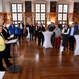 Eine Gruppe von etwa 20 Personen im Rathaus