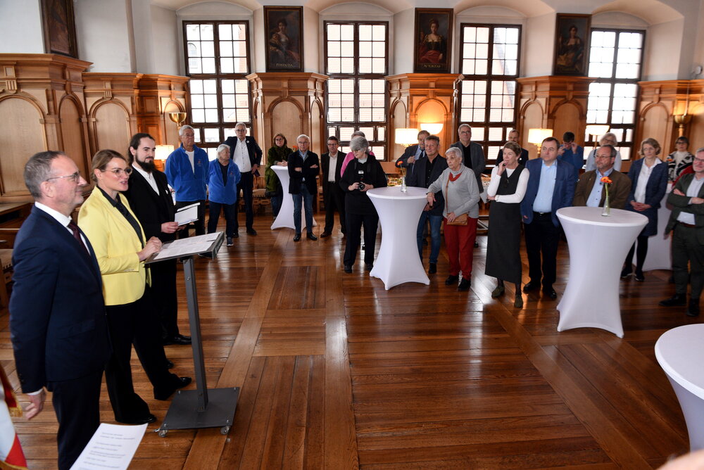 Eine Gruppe von etwa 20 Personen im Rathaus