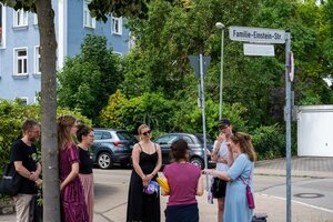 Teilnehmer einer Führung unter einem Strassenschild