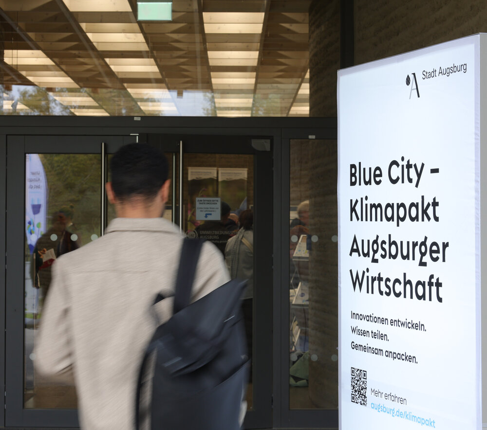 Mann mit Rucksack läuft an Leuchtschild vorbei