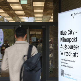 Mann mit Rucksack läuft an Leuchtschild vorbei