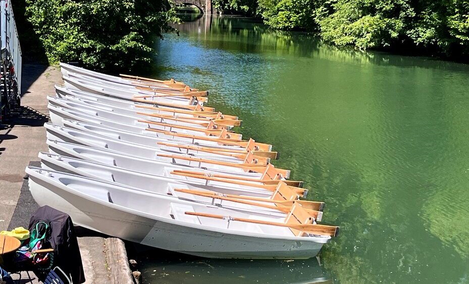 Weiße Ruderboote stehen an der Augsburger Kahnfahrt bereit