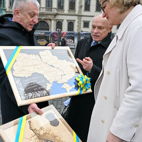 Das Foto zeigt den Bürgermeister von Perwomajsk Oleh Demchenko, wie er Geschenke an Oberbürgermeisterin Eva Weber übergibt