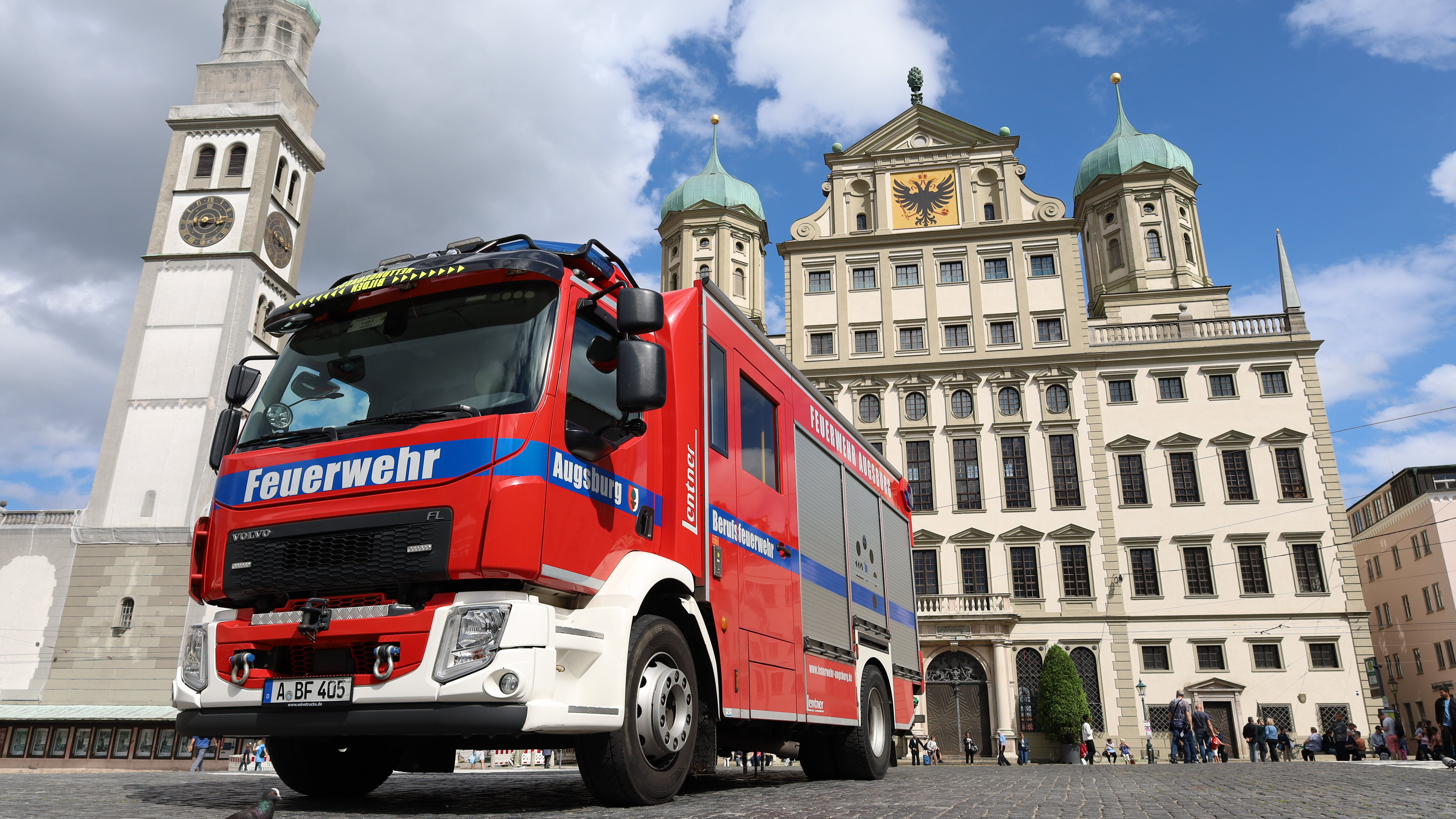 Ein großes Feuerwehrauto steht auf dem Rathausplatz. Im Hintergrund sieht man das Rathaus und den Perlachturm