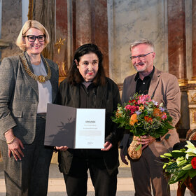 Oberbürgermeisterin Eva Weber und Kulturreferent Enninger übergeben die Urklunde