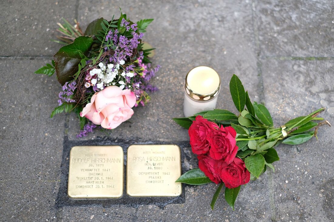 Stolperstein mit Blumen und eineer Erinnerungskerze