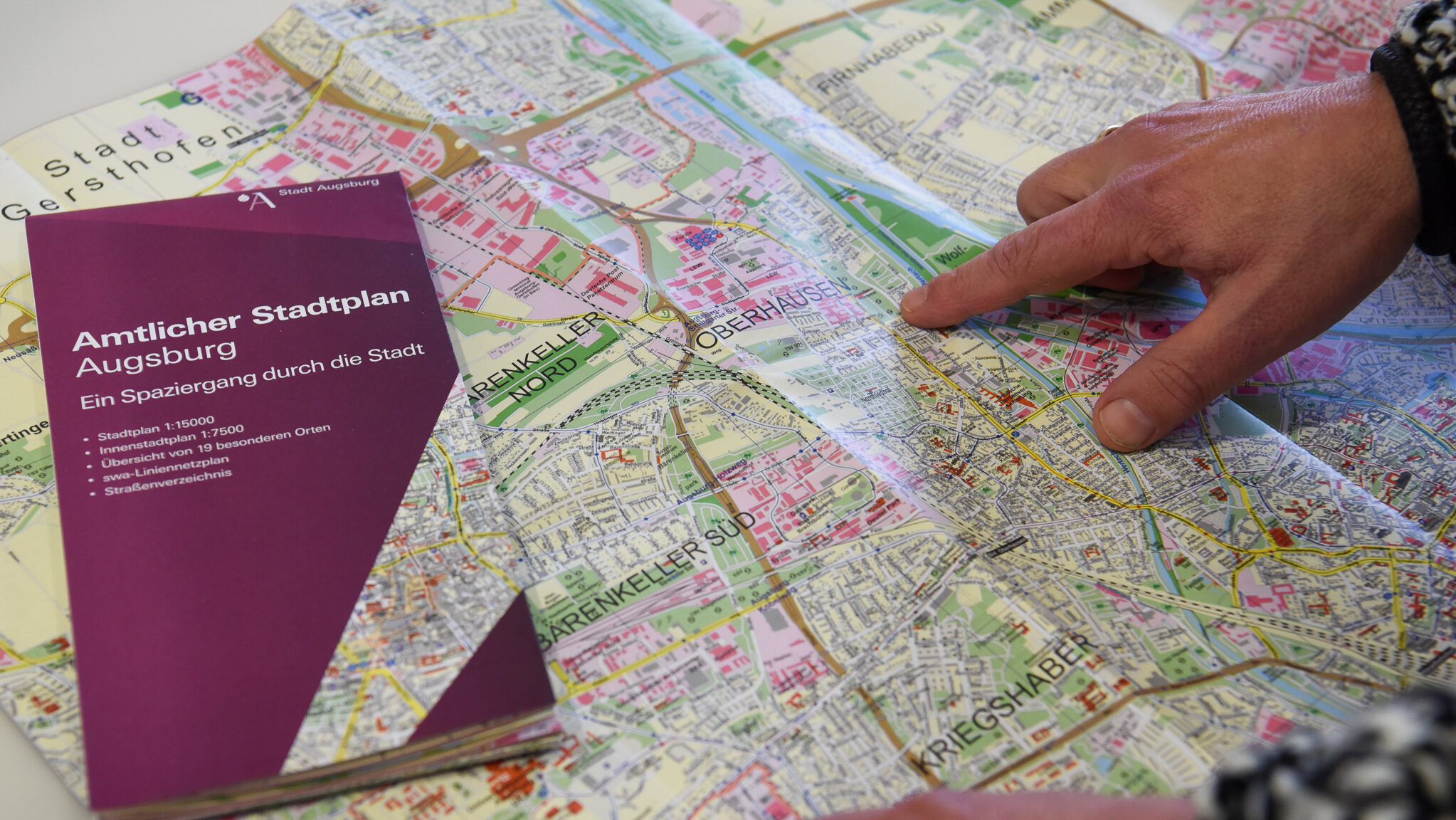 Eine Hand zeigt auf einen Stadtplan
