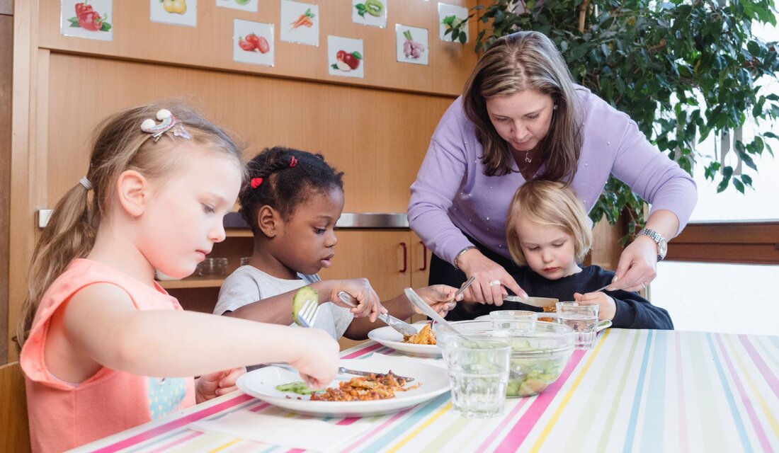 Kinderpflegerin hilft beim Essen Kinderpflegerin hilft beim Essen