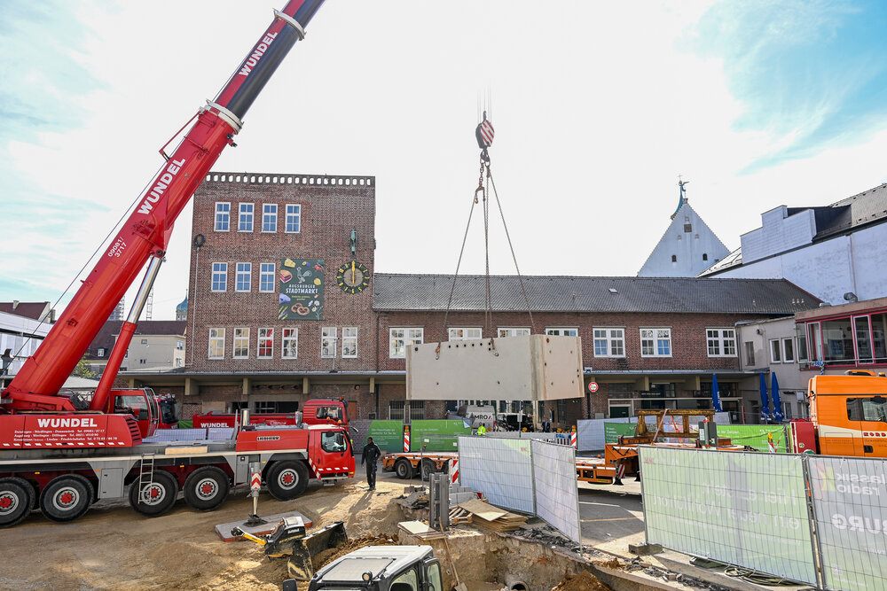 Einsetzen der Brunnenkammer auf dem Bauernmarkt. 