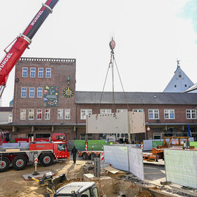 Einsetzen der Brunnenkammer auf dem Bauernmarkt. 