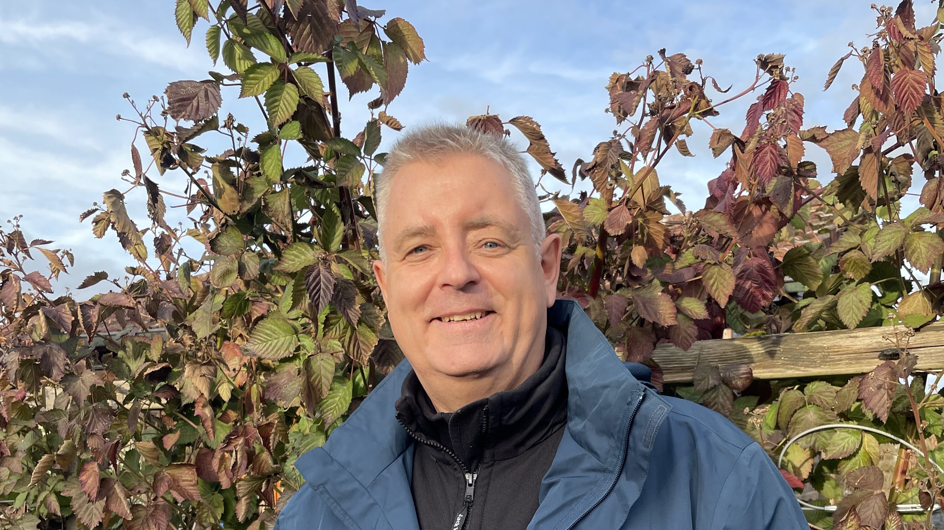 ein älterer Mann hält lächelnd ein Wespennest in beiden Händen