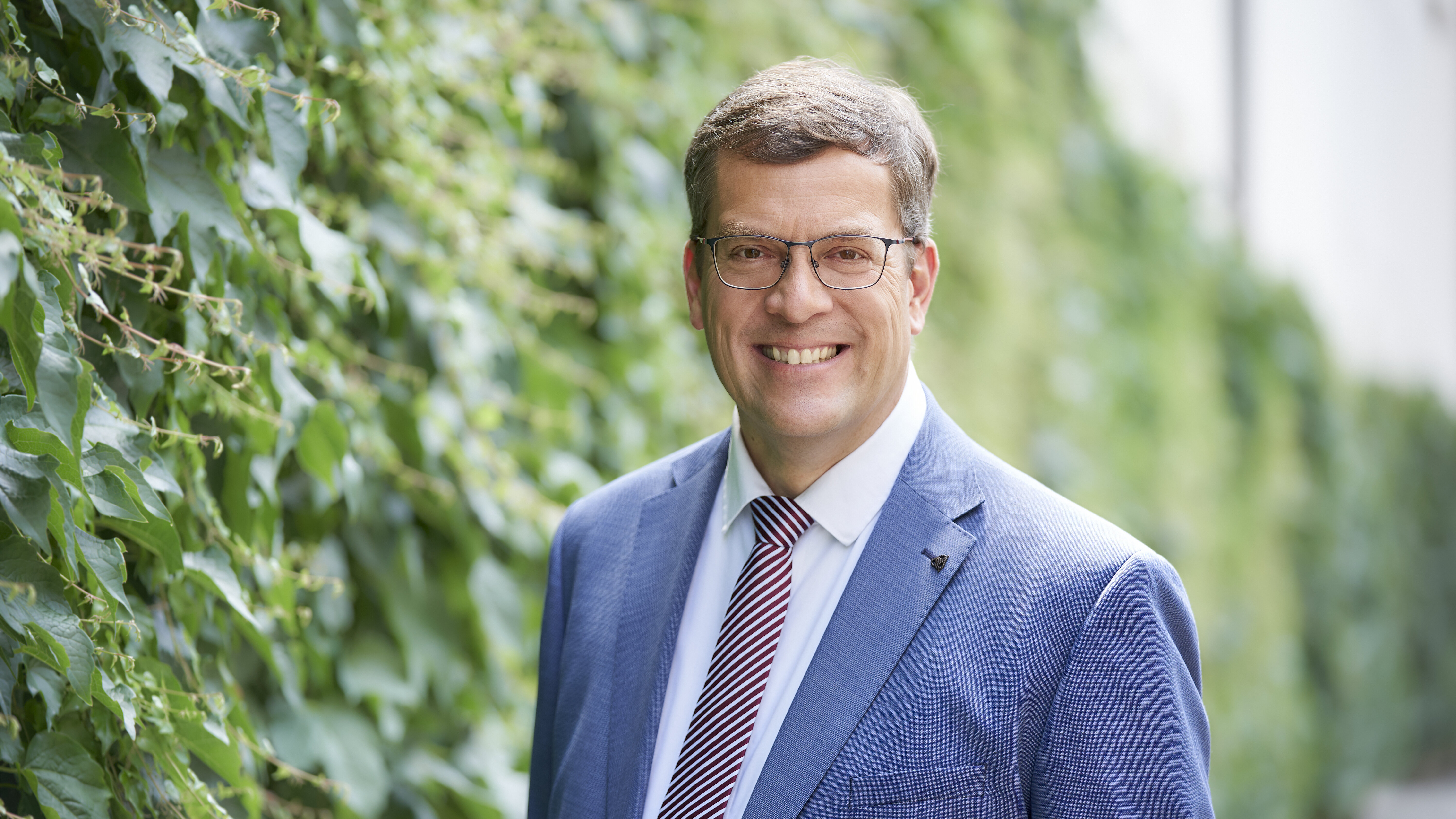 Bürgermeister Bernd Zitzelsberger im Anzug vor einer grünen Hecke