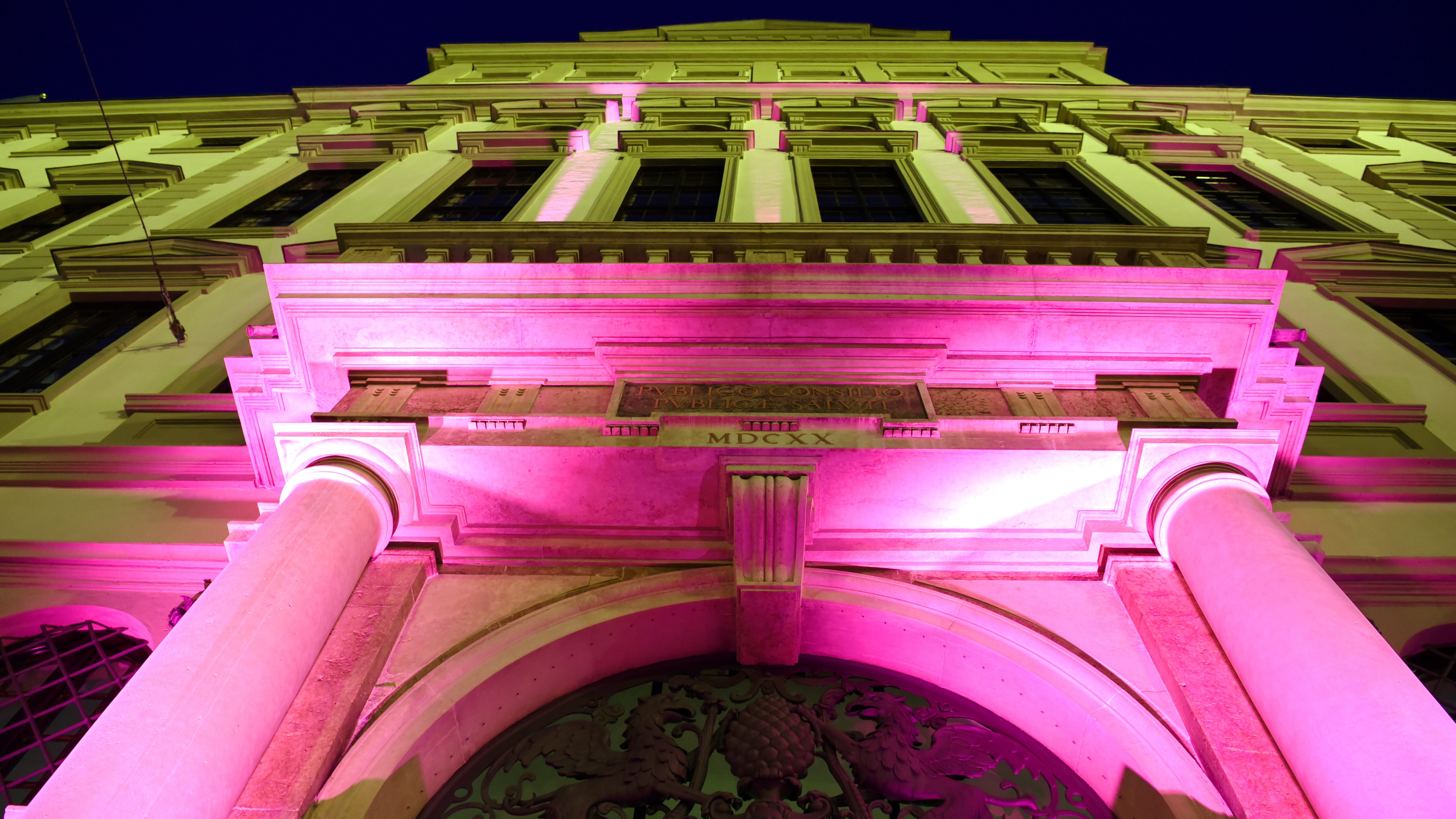 Das Rathaus bei Nacht. Das große Tor ist Pink beleuchtet