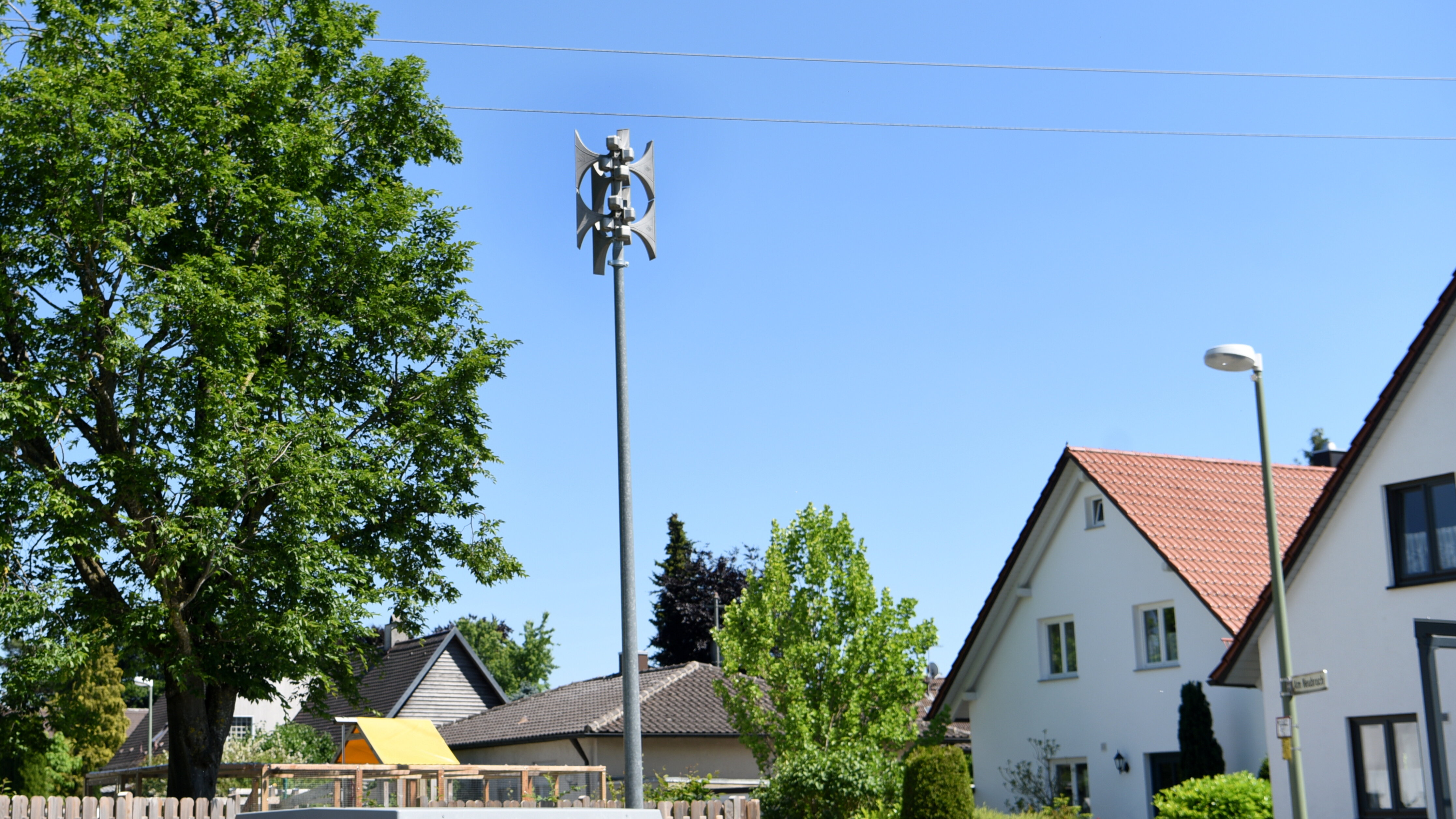 Eine Sirene auf einem hohen Mast in einem Wohngebiet