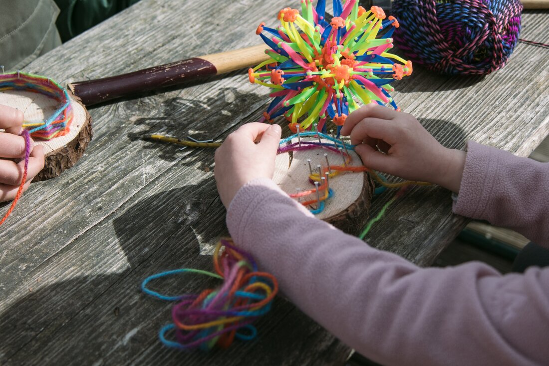 Kinder basteln mit Wolle und Holzscheiben