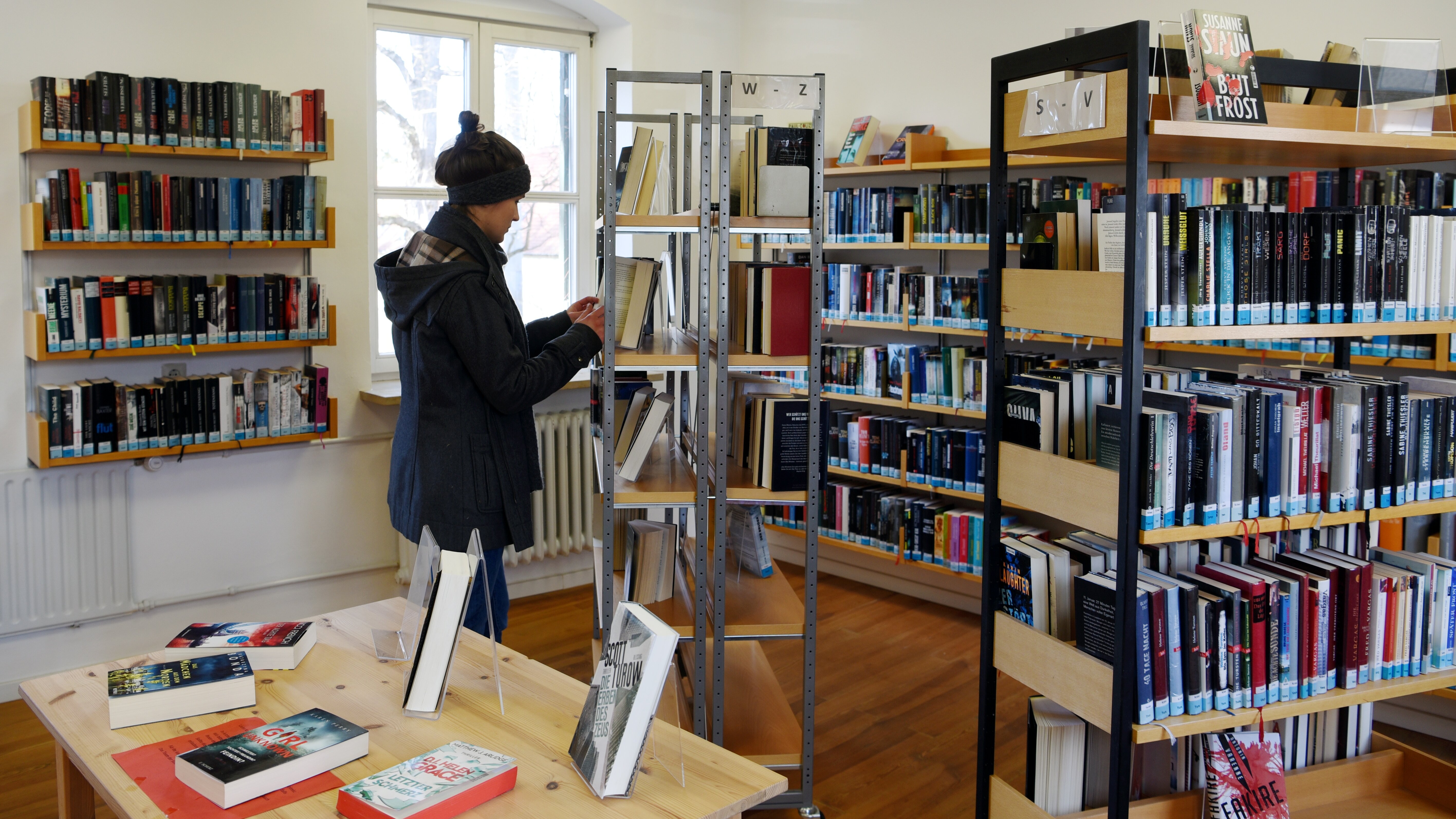 Eine Frau steht zwischen Regalen voller bücher