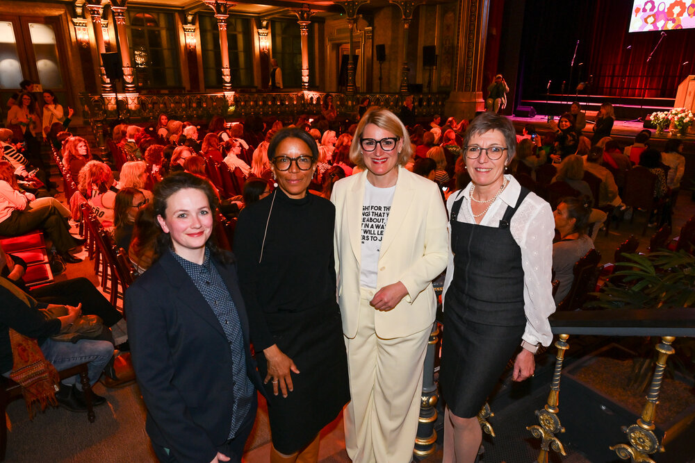 Das Foto zeigt vier festlich gekleidete Frauen, im Hintergrund das Parktheater