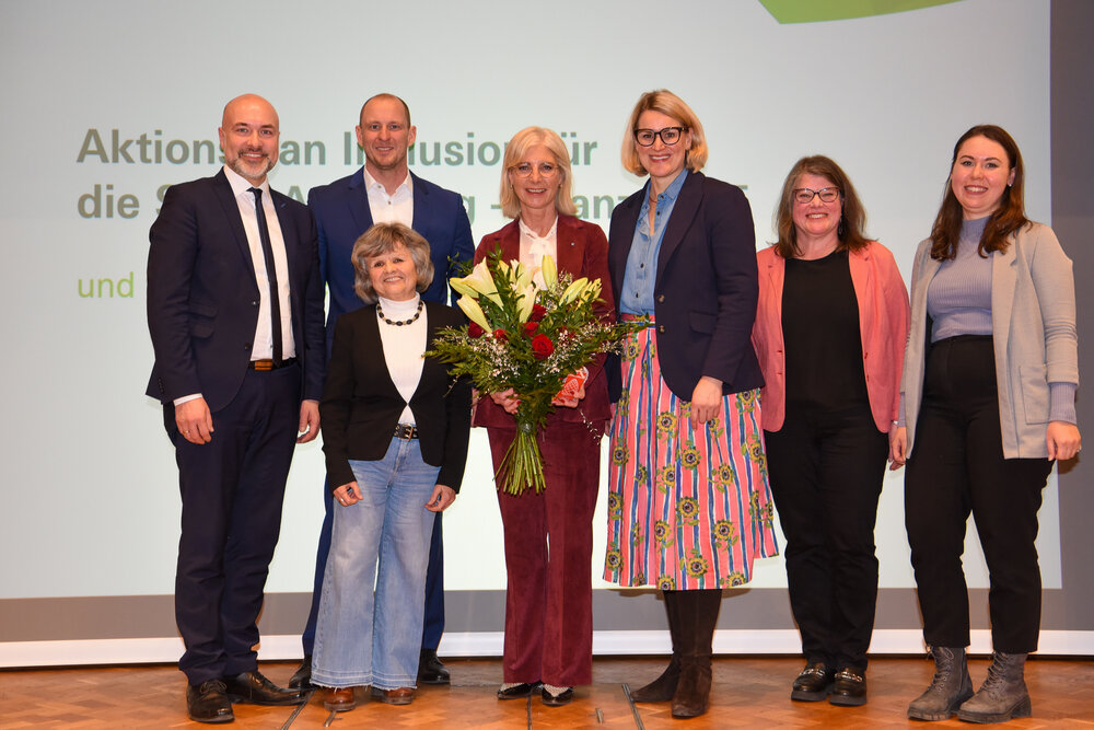Gruppenbild mit 2 Männern, 5 Frauen und einem Blumenstrauß