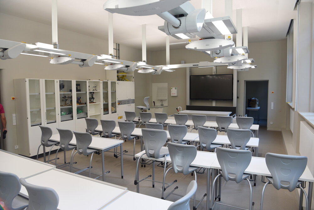 Klassenraum mit weißen Möbeln und futuristischer Beleuchtung 