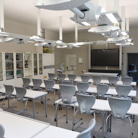 Klassenraum mit weißen Möbeln und futuristischer Beleuchtung 
